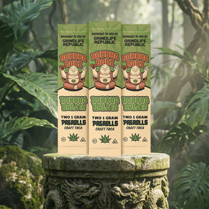 Three packages of Buddha Breath pre-rolls on a stone pedestal with a natural background