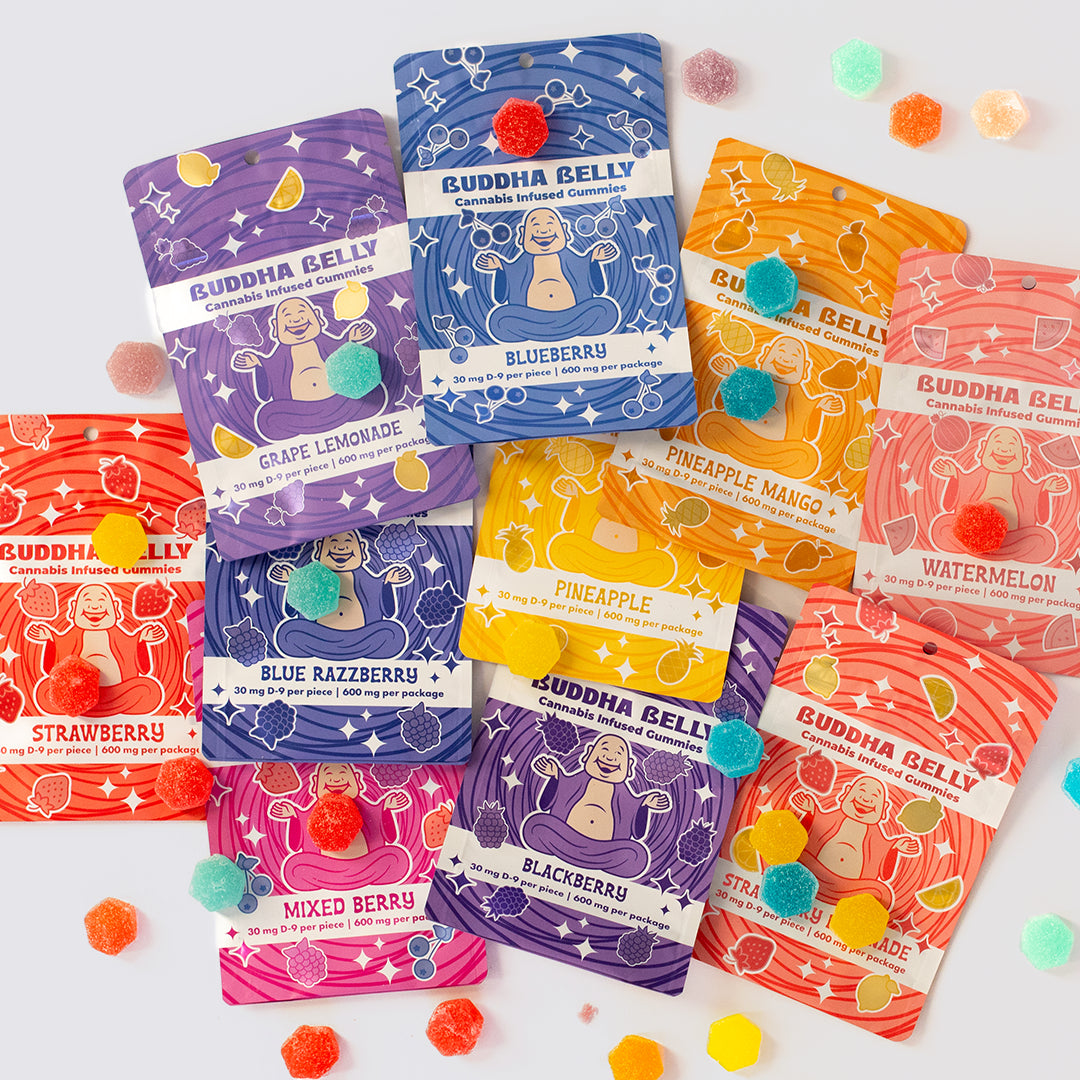 Colorful packaging of Buddha Belly cannabis gummy products on a white background with candy accents.